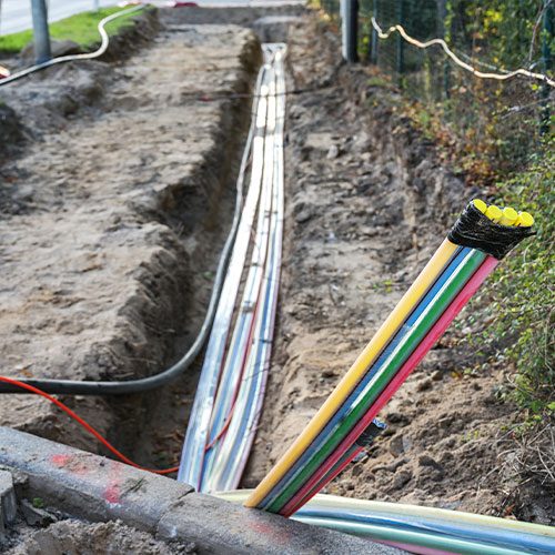 Verlegte Leitungen und Kabel in einem offenen Kabelgraben
